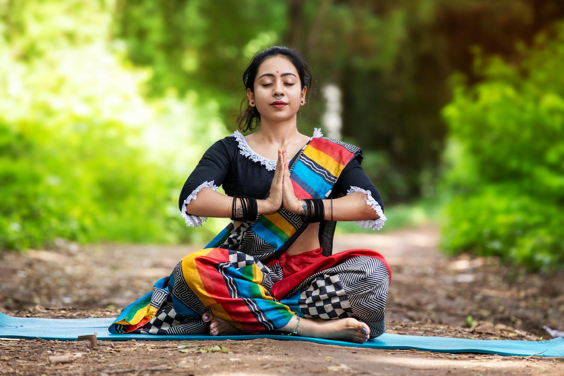 Woman meditating peacefully in a sunlit room as part of her morning routine to reduce stress.